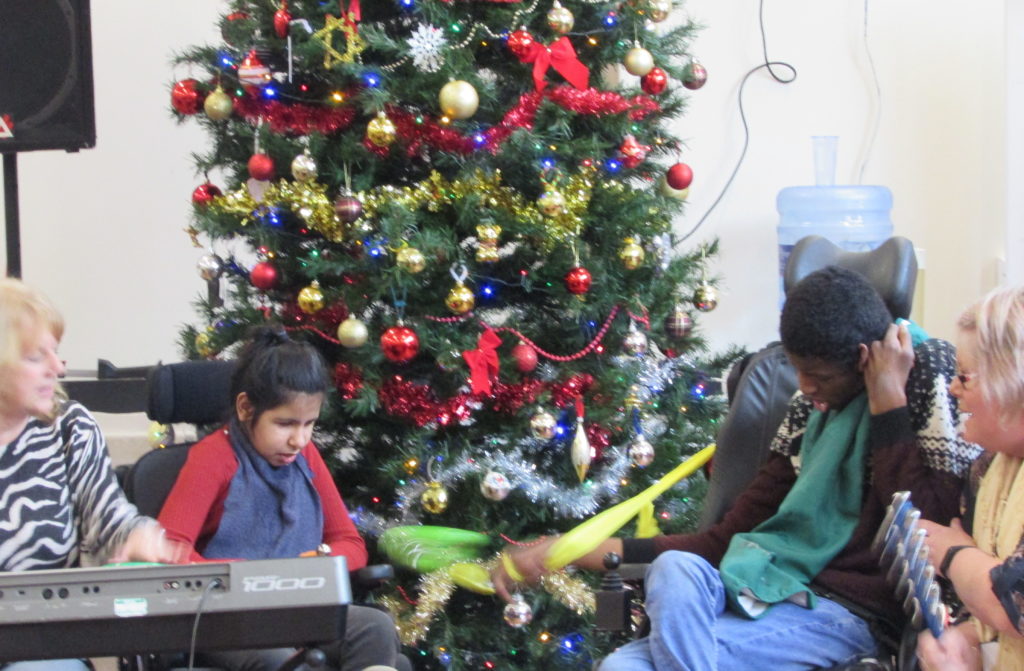 Students playing music in front of Christmas tree at Craig Y Parc