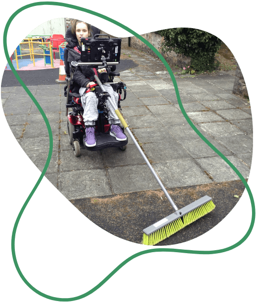Student in a wheelchair using accessible sweeping brush graphic